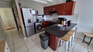 a small kitchen with a counter and a refrigerator at Urben Loft - Back up Power in Cape Town