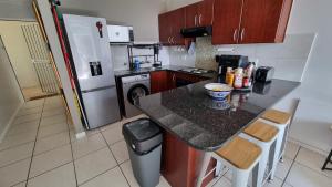 a small kitchen with a counter and a refrigerator at Urben Loft - Back up Power in Cape Town