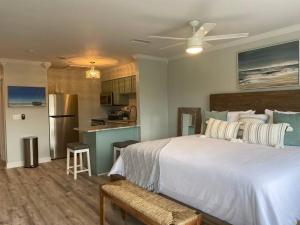 a bedroom with a large bed and a kitchen at Destin Bliss! Your Dream Studio Condo on Holiday Isle! in Destin
