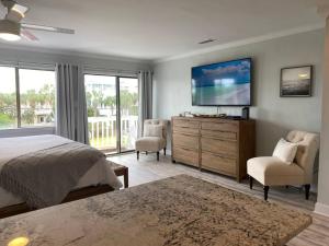 um quarto com uma cama e uma televisão de ecrã plano em Destin Bliss! Your Dream Studio Condo on Holiday Isle! em Destin