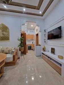Casa Riad Amor Marrakech en Lo Pagan في سان بييدرو ديل بيناتار: غرفة معيشة مع تلفزيون كبير وأريكة