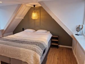 een slaapkamer met een bed op de zolder bij Tip! Noordwijk city center house in Noordwijk aan Zee