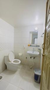 a white bathroom with a toilet and a sink at Chittagong Hotel & Apartment Service in Dhaka