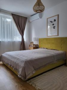 um quarto com uma cama grande e uma janela em Concordia - apartament nou amenajat - lângã Cazino em Băile Herculane