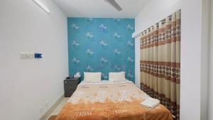 a bedroom with a bed and a blue wall at Chittagong Hotel & Apartment Service in Dhaka