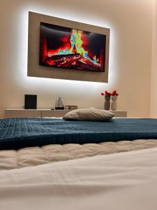 a bedroom with a bed with a tv on the wall at Mael Superior Room in Palermo