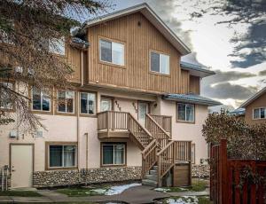 a large house with a staircase in front of it at Big Mountain Views - 2-story Corner Unit in Canmore