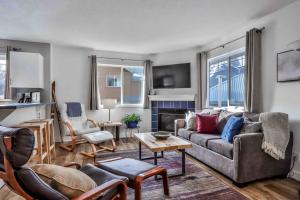 a living room with a couch and a table at Big Mountain Views - 2-story Corner Unit in Canmore