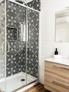 uma casa de banho com um chuveiro com um padro preto e branco em Quinta Costa da Estrela em Gouveia mais 26 fotografias