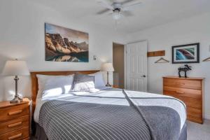a bedroom with a bed and a ceiling fan at Big Mountain Views - 2-story Corner Unit in Canmore
