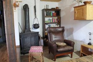ein Wohnzimmer mit einem Stuhl und einem Herd in der Unterkunft Ferienhaus Aschoff in Mauchen