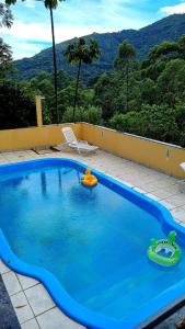 una gran piscina azul con 2 juguetes. en Chalés Canton Suisse, en Nova Friburgo