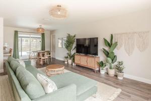 a living room with a couch and a tv at 10 Mins to Beach - 2BR Private Pool + Spa + Grill in Vero Beach