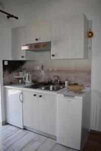 a kitchen with white cabinets and a sink at Studio apartman Tasha in Opatija