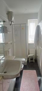 ein weißes Bad mit einem Waschbecken und einem WC in der Unterkunft Da Teresa in Siderno Marina