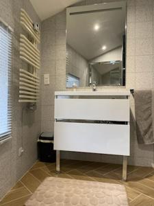 La salle de bains est pourvue d'un lavabo blanc et d'un miroir. dans l'établissement 4 star CABARET Lastours 4 Châteaux amazing Cathar landmark Private luxury 4 Star air conditioned Terrasse with views, à Lastours
