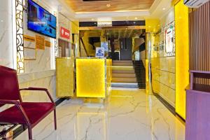 a lobby with yellow walls and a chair in a building at Trans World Hotel in Dubai