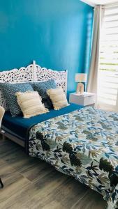 - une chambre dotée d'un lit avec un mur bleu dans l'établissement Carpe Diem Spacieux élégant et confortable appartement idéal pour les séjours professionnels, à Les Abymes