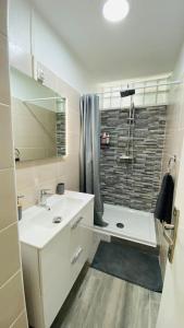 baño blanco con ducha y lavamanos en Carpe Diem Spacieux élégant et confortable appartement idéal pour les séjours professionnels en Les Abymes