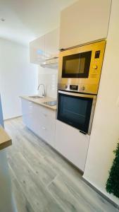cocina con microondas en la pared en Carpe Diem Spacieux élégant et confortable appartement idéal pour les séjours professionnels en Les Abymes
