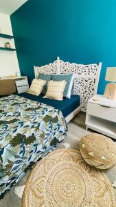 um quarto com uma cama e uma parede azul em Carpe Diem Spacieux élégant et confortable appartement idéal pour les séjours professionnels em Les Abymes