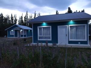 een blauw huis met lichten erop bij Cabañas deja vu in El Calafate