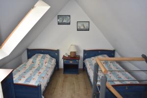 een slaapkamer op zolder met 2 bedden en een tafel bij Ker Moumousse in Trébeurden