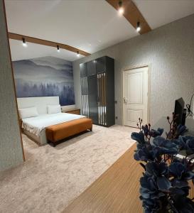 VİVA BOUTIQUE & MIRROR DELUXE HOTEL's BAKU في باكو: غرفة نوم بسرير ودهان على الحائط