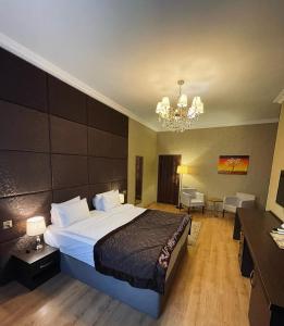 a hotel room with a large bed and a chandelier at VİVA BOUTIQUE & MIRROR DELUXE HOTEL's BAKU in Baku