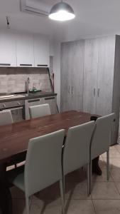 una cucina con tavolo in legno e sedie bianche di Sweet Home Tempo Libero a San Severo