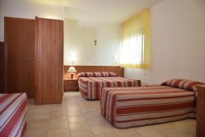 A bed or beds in a room at Hotel e Appartamenti La Solaria