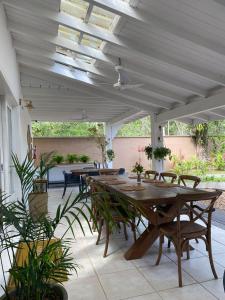 a patio with tables and chairs under a roof at Casa Hotel Sahy in Barra do Sahy