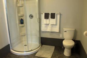 a bathroom with a shower and a toilet and towels at Suite #B, Industrial Styling, AC in Halifax
