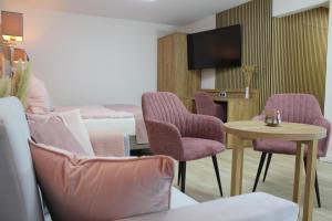 een hotelkamer met paarse stoelen en een tafel en een bed bij Apartment „Amalia“ in Ergersheim