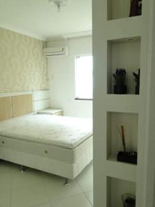 um quarto branco com uma cama e uma janela em Excelente apartamento em Itapema