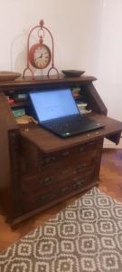 a laptop computer sitting on a desk with a clock at Casa Mateus - Colares, Parque Natural Sintra Cascais in Sintra