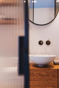 een badkamer met een witte wastafel en een spiegel bij IN2 BnB in Solothurn