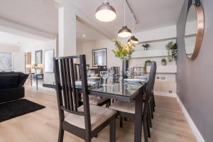 a dining room with a glass table and chairs at The Hamptons by Brighton Holiday Lets in Brighton & Hove