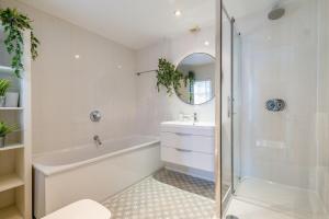 a white bathroom with a tub and a sink at The Hamptons by Brighton Holiday Lets in Brighton & Hove