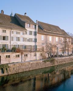 een groep gebouwen naast een rivier bij IN2 BnB in Solothurn