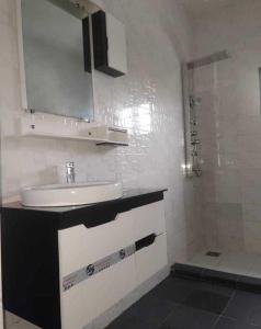a white bathroom with a sink and a shower at Dapi Home Residence in Lomé