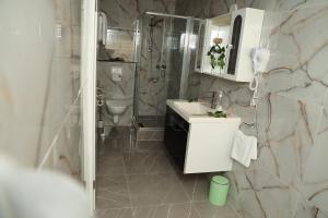 a bathroom with a toilet and a sink and a shower at Hotel Royal in Bad Salzuflen +35 photos