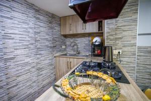 a kitchen with a stove with a bowl of fruit on the counter at city point in Kutaisi