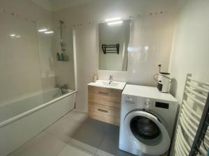 W łazience znajduje się pralka i umywalka. w obiekcie Un extérieur en ville w mieście Cherbourg en Cotentin