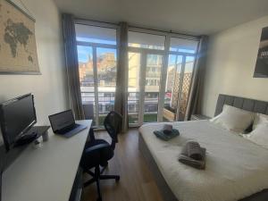 a bedroom with a bed and a desk with a laptop at Un extérieur en ville in Cherbourg en Cotentin