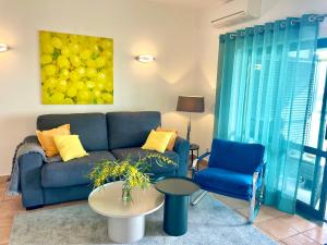 sala de estar con sofá azul y 2 sillas en T1 Marina Park Vista Mar, en Lagos