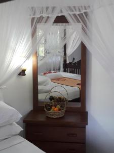 Lucky Prince Villa في ألوثغاما: غرفة نوم مع مرآة وسلة فاكهة على خزانة