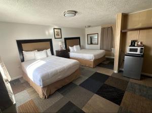 a hotel room with two beds and a microwave at Motel Nicholas in Omak