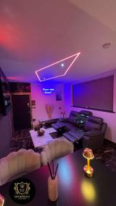 sala de estar con iluminación púrpura y sofá en HIGHFIELD PRIVATE SPA APARTMENT en Bradford