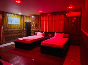 - 2 lits dans une chambre avec éclairage rouge dans l'établissement Hotel Swargalok, à Pānigata